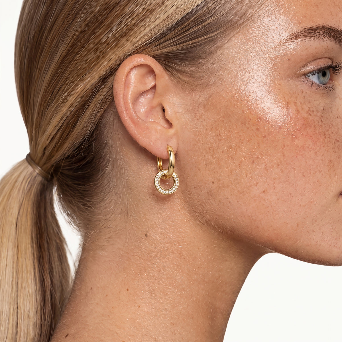 Gold-tone interlocking hoop earring worn in the ear