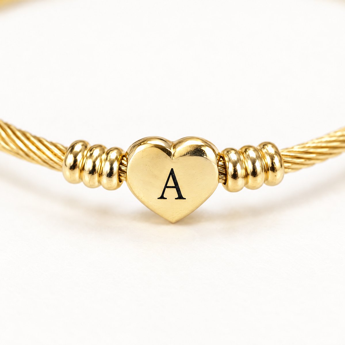 Close up of the engraved letter on the gold-tone heart charm