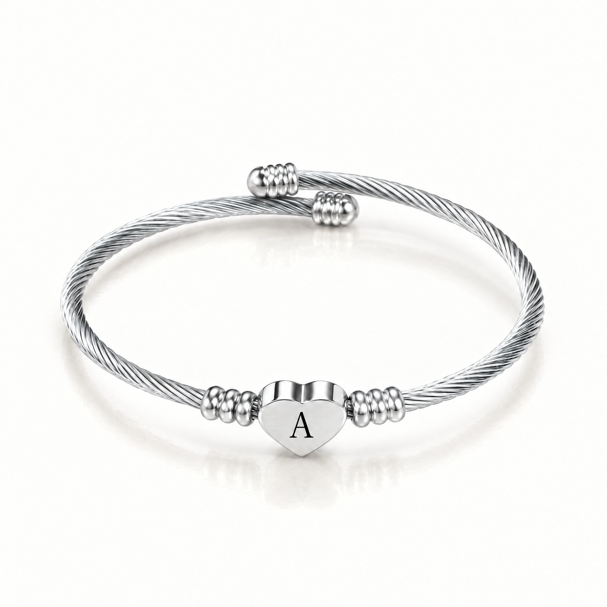 Silver-tone twisted cuff bangle with an engraved letter heart charm
