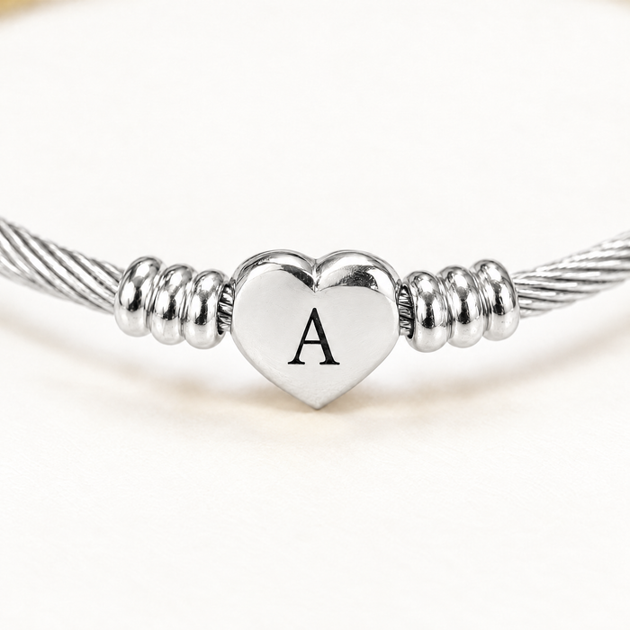 Close up of the engraved letter on the silver-tone heart charm