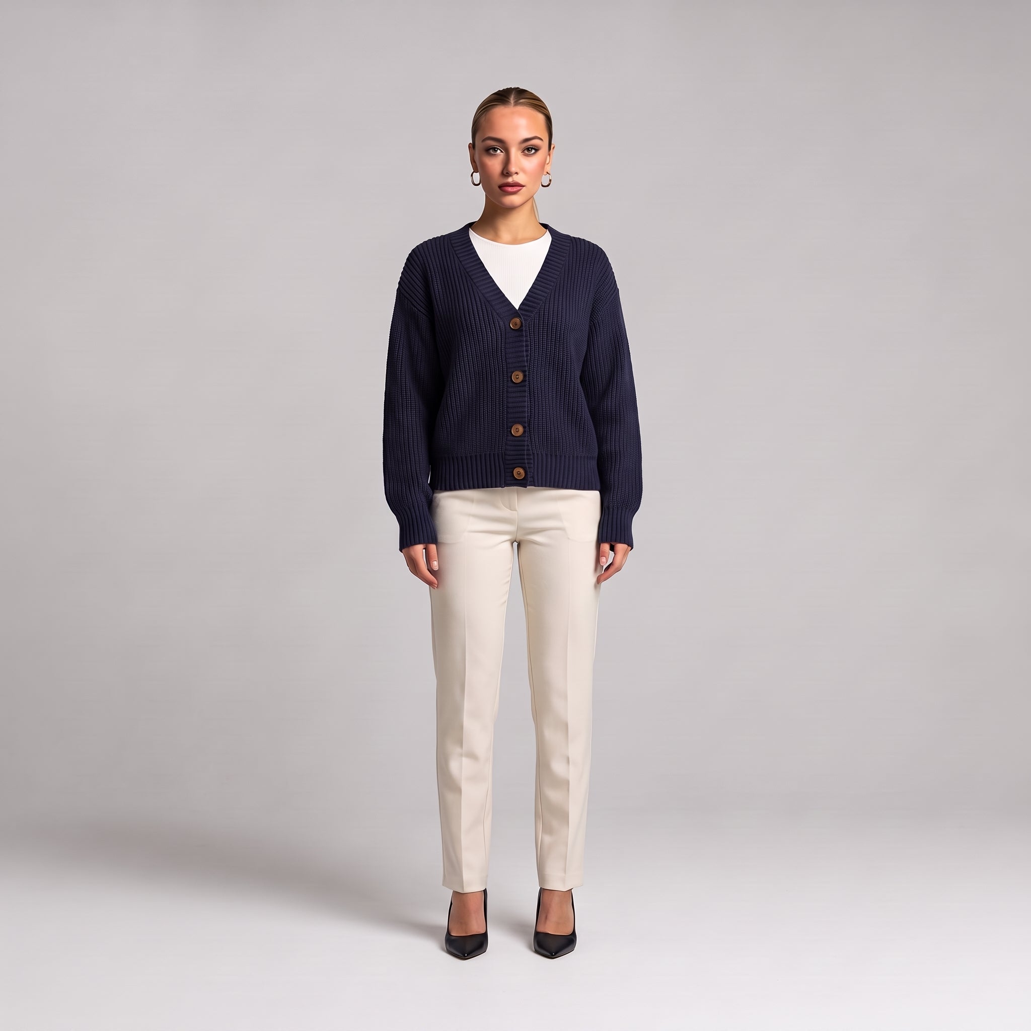 Navy chunky knit cardigan worn open over a white top, full length front view