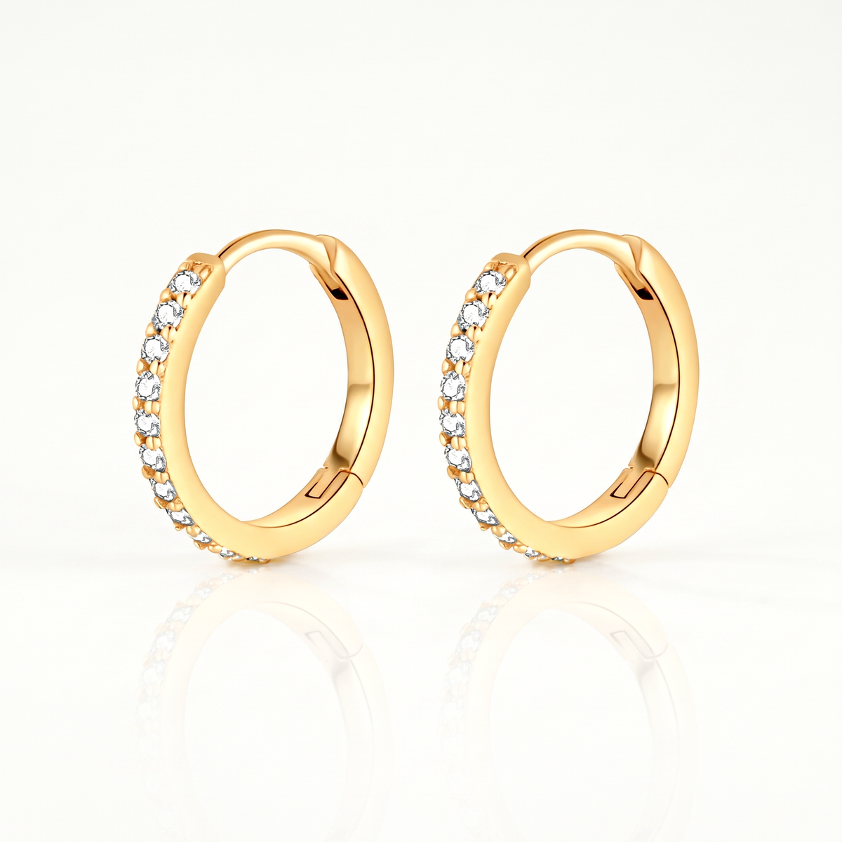 Gold-tone crystal huggie hoop earrings, pair shown from the front