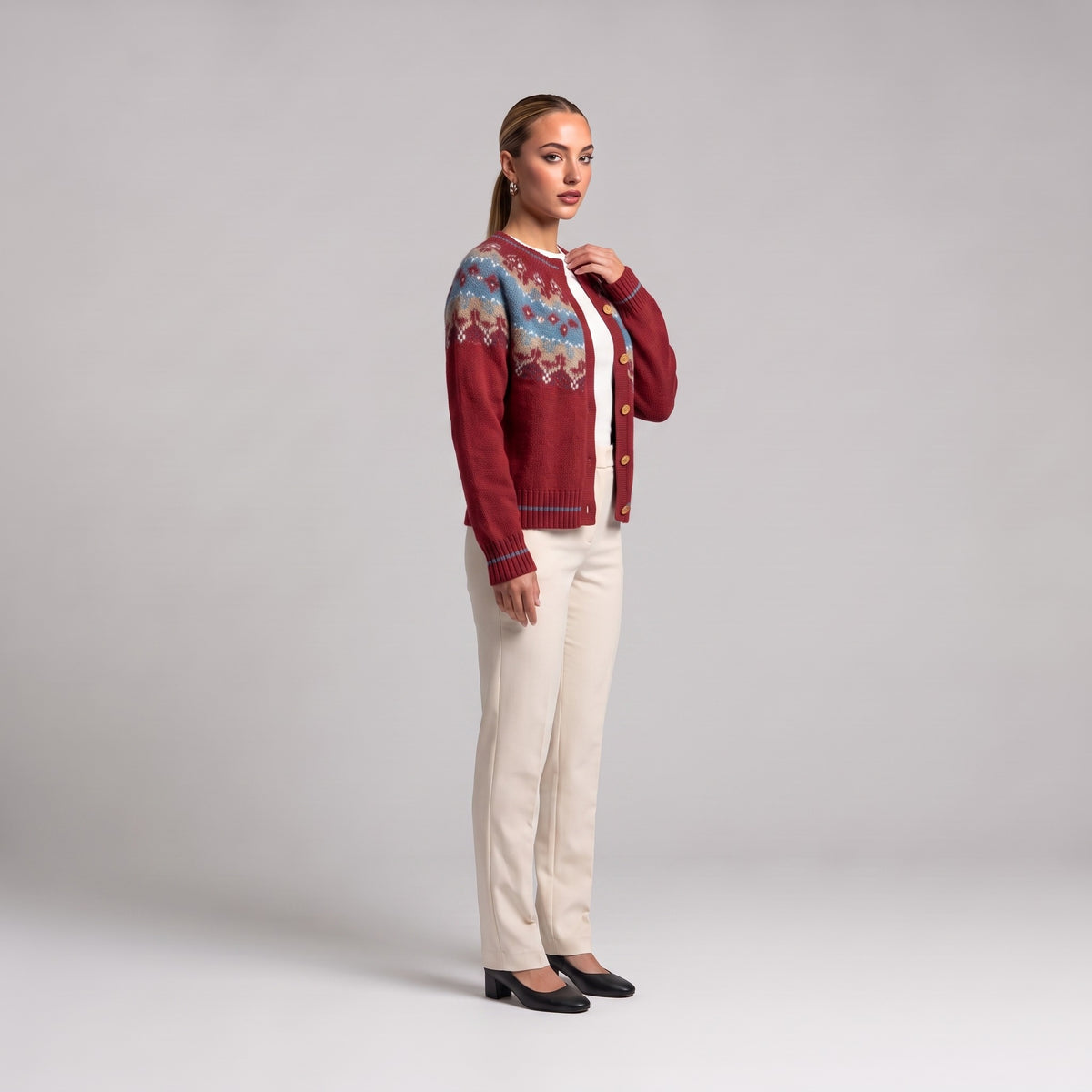 Red Fair Isle Christmas cardigan, side view worn with cream trousers
