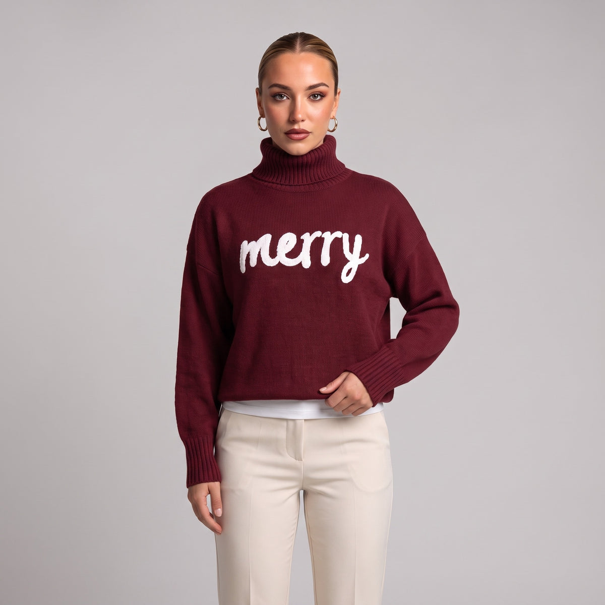Close-up of burgundy merry roll neck Christmas jumper on model