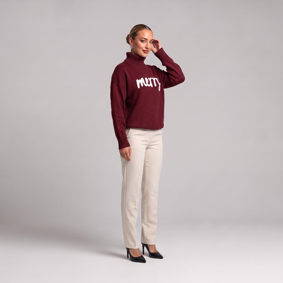 Burgundy merry roll neck Christmas jumper, three quarter view on model