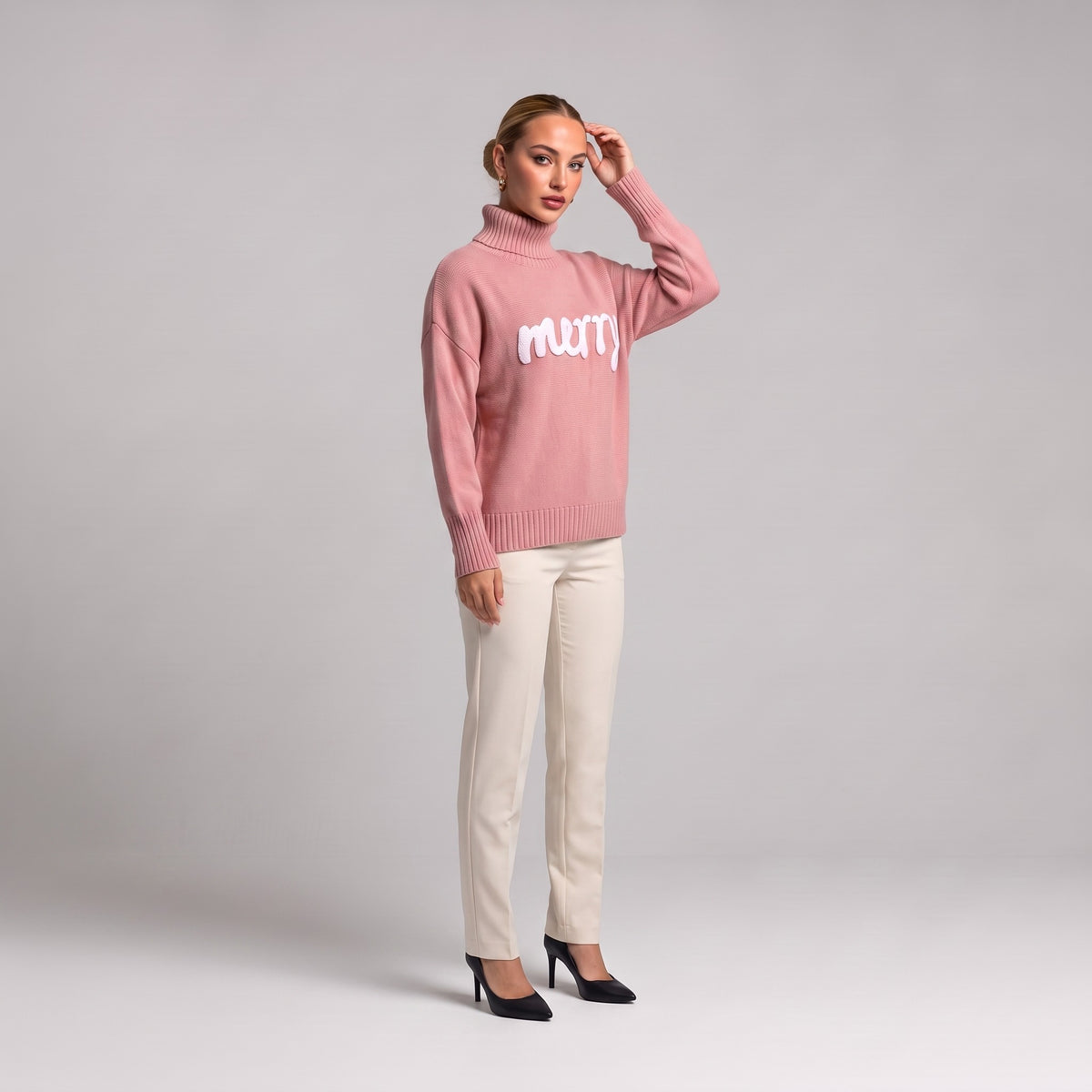 Pink merry roll neck Christmas jumper, three quarter view on model