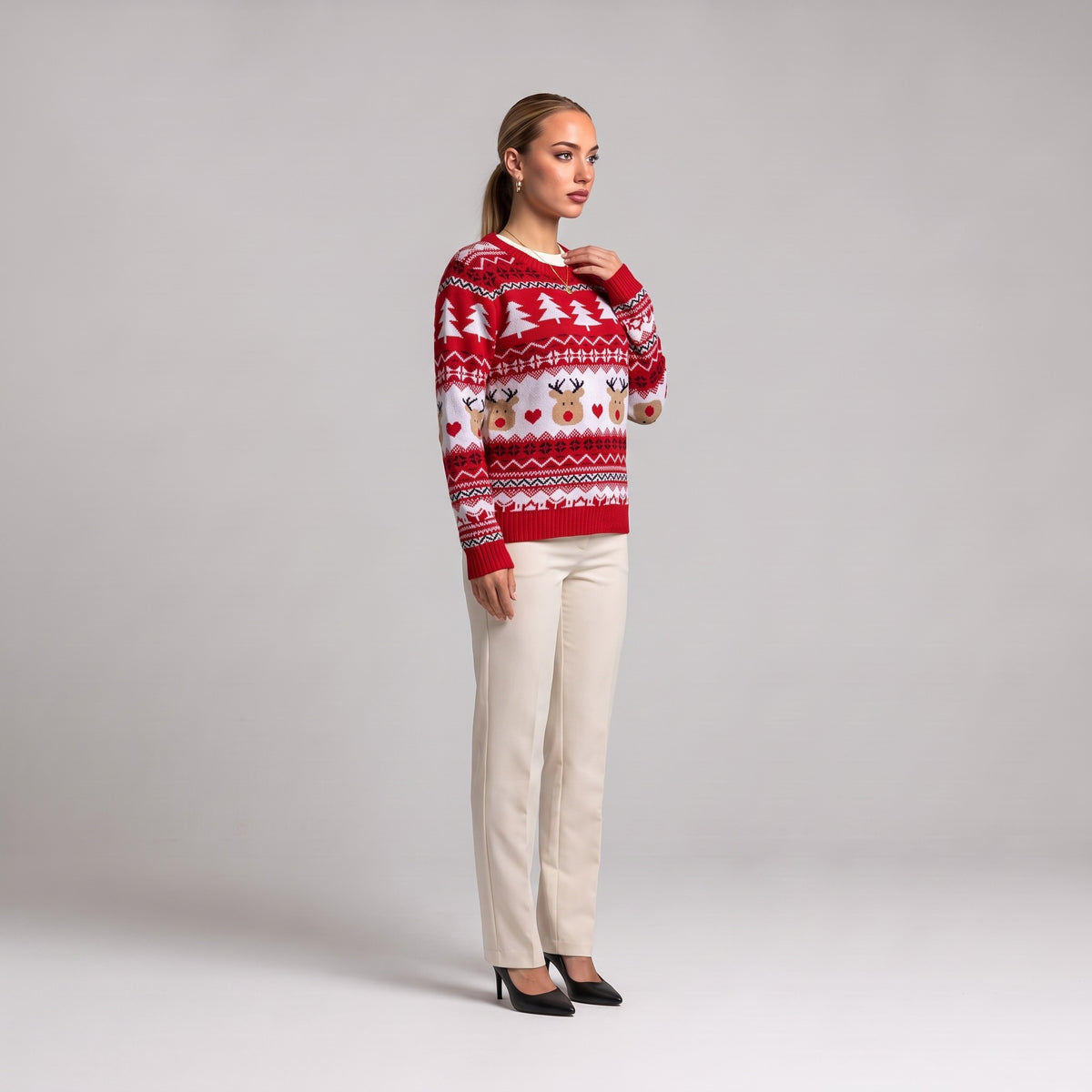 Red Fair Isle reindeer Christmas jumper, side view worn with cream trousers