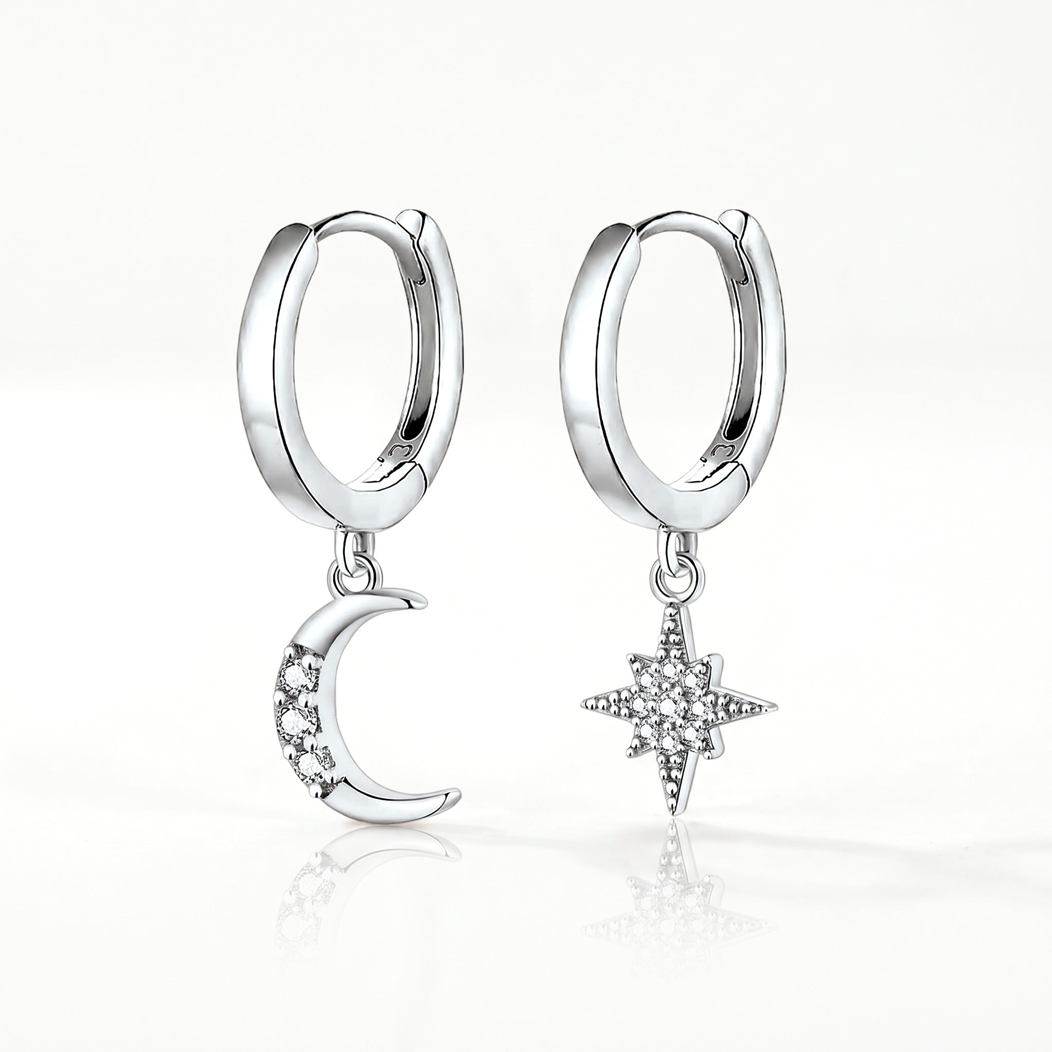 Silver-tone moon and star huggie earrings, pair shown from the front