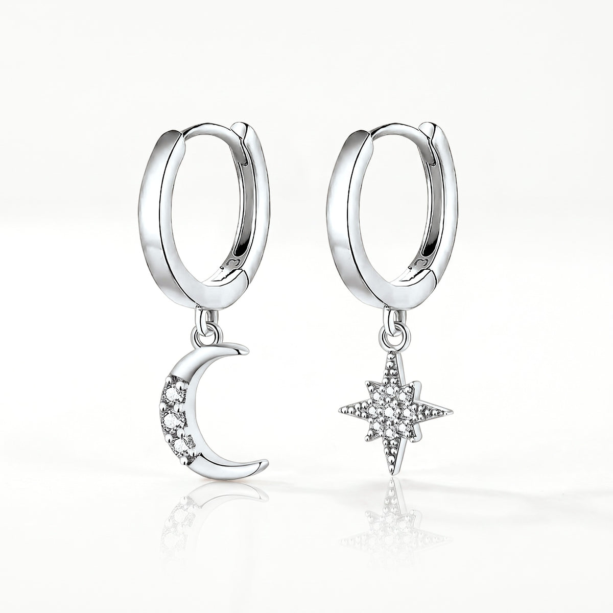 Silver-tone moon and star huggie earrings, pair shown from the front