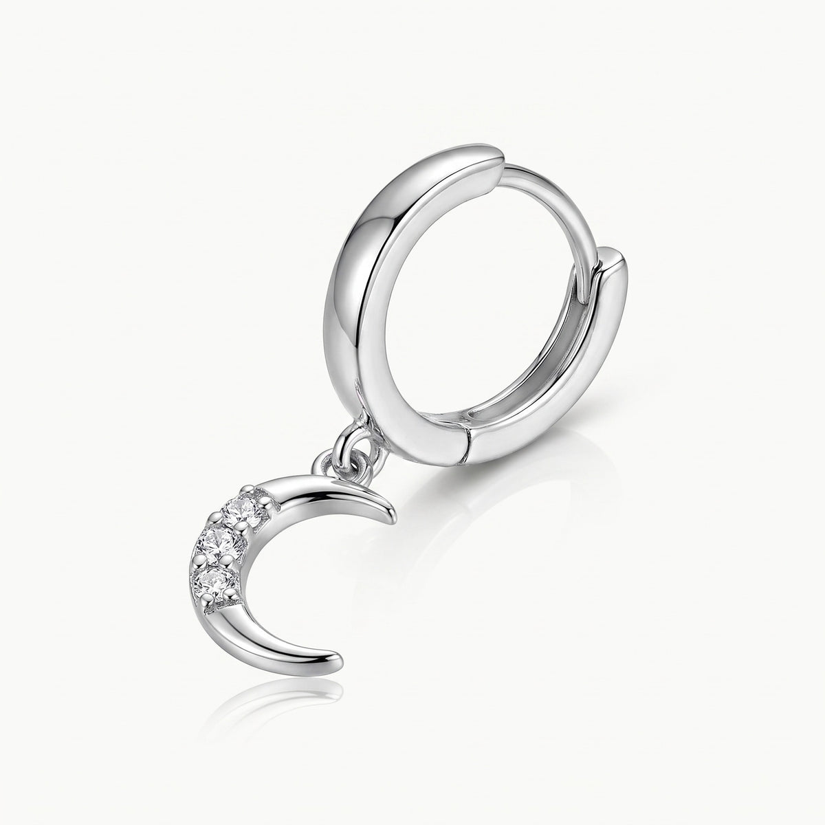 Close-up of a silver-tone charm and hinged huggie hoop