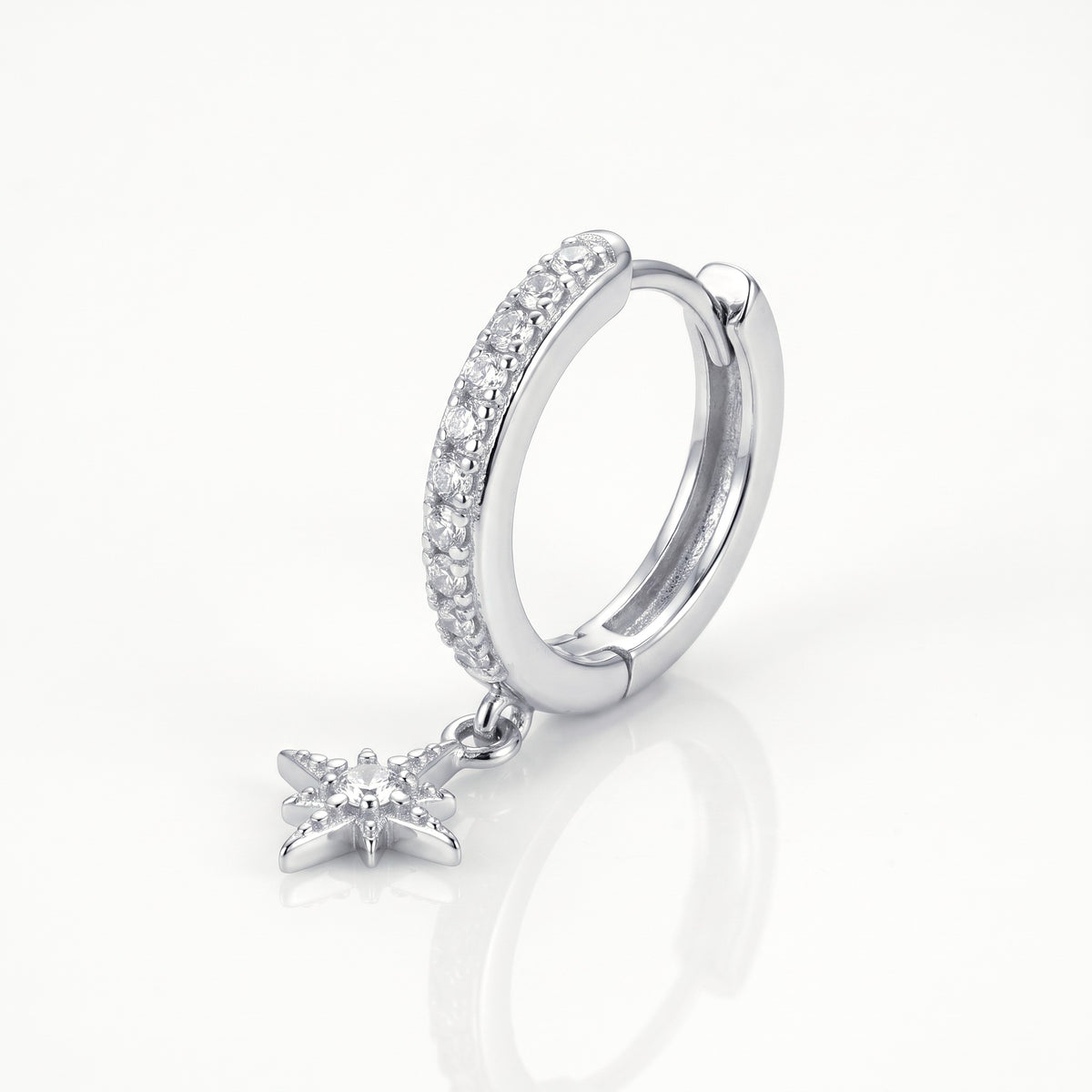 Close-up of the silver-tone star charm huggie hoop earrings