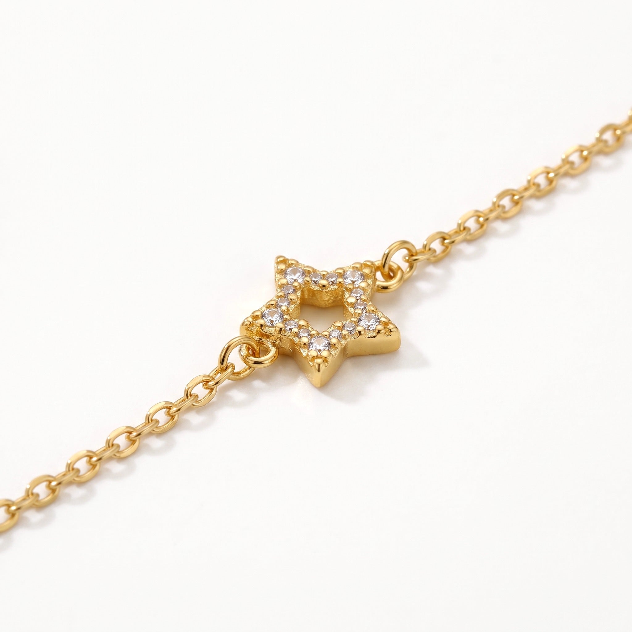 Close-up of the open crystal star charm on the gold-tone chain