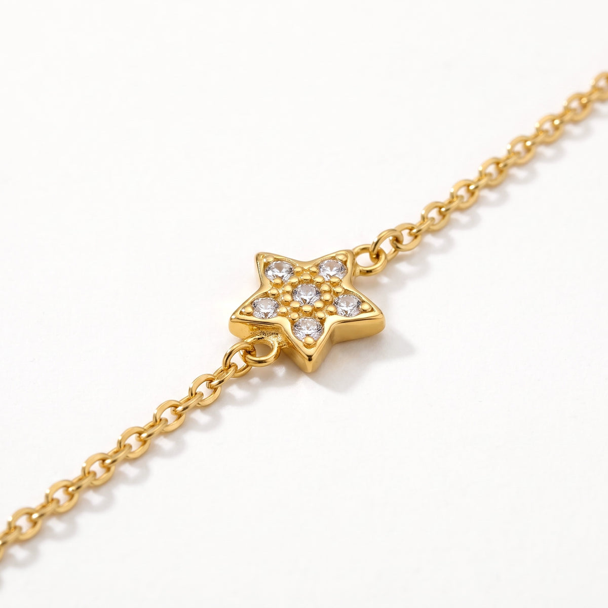 Close-up of the crystal star charm on the gold-tone chain