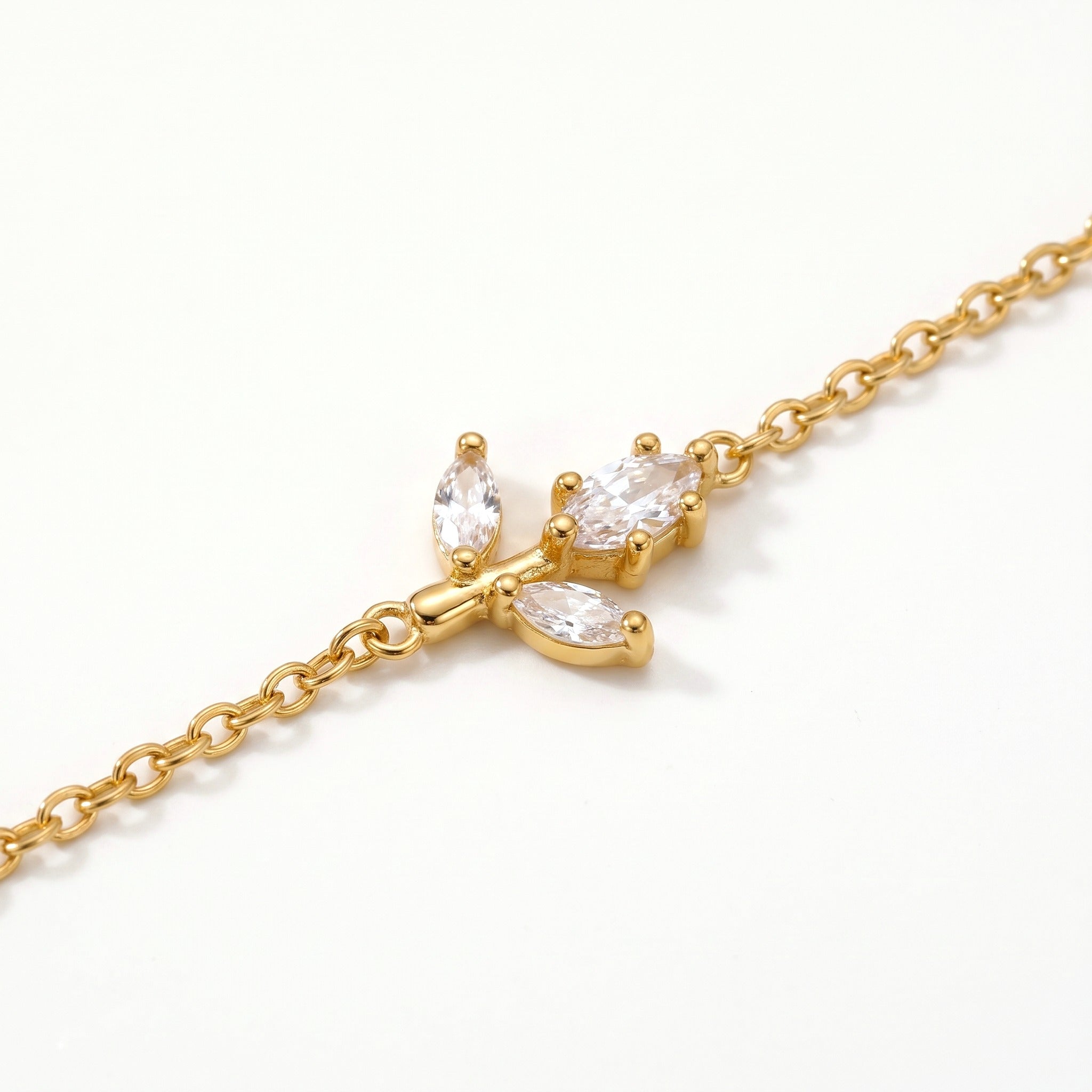 Close-up of the crystal sprig charm on the gold-tone chain