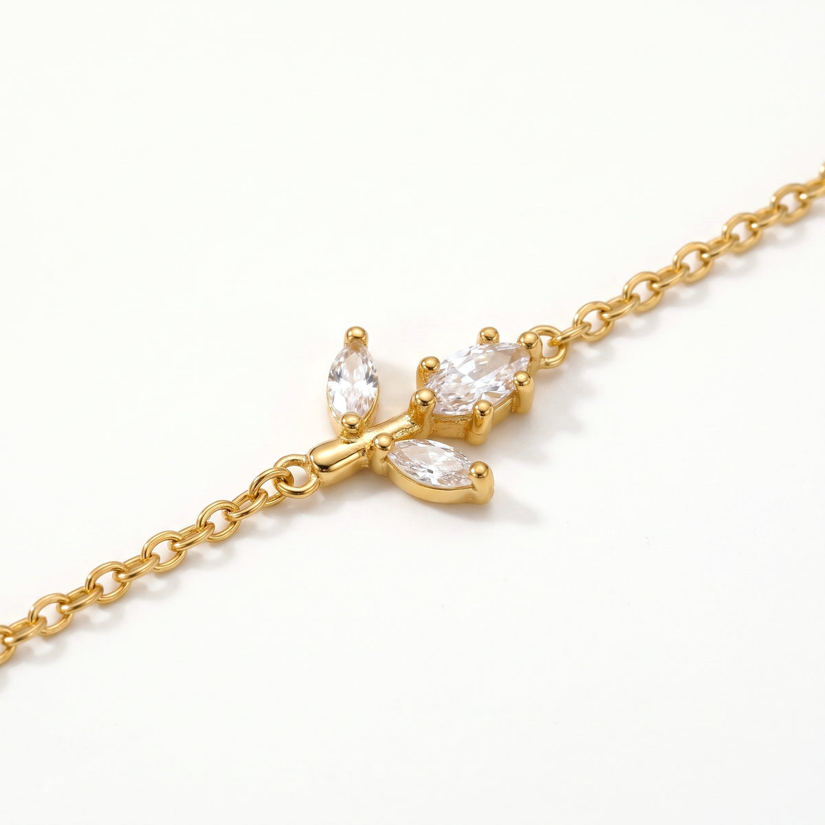 Close-up of the crystal sprig charm on the gold-tone chain