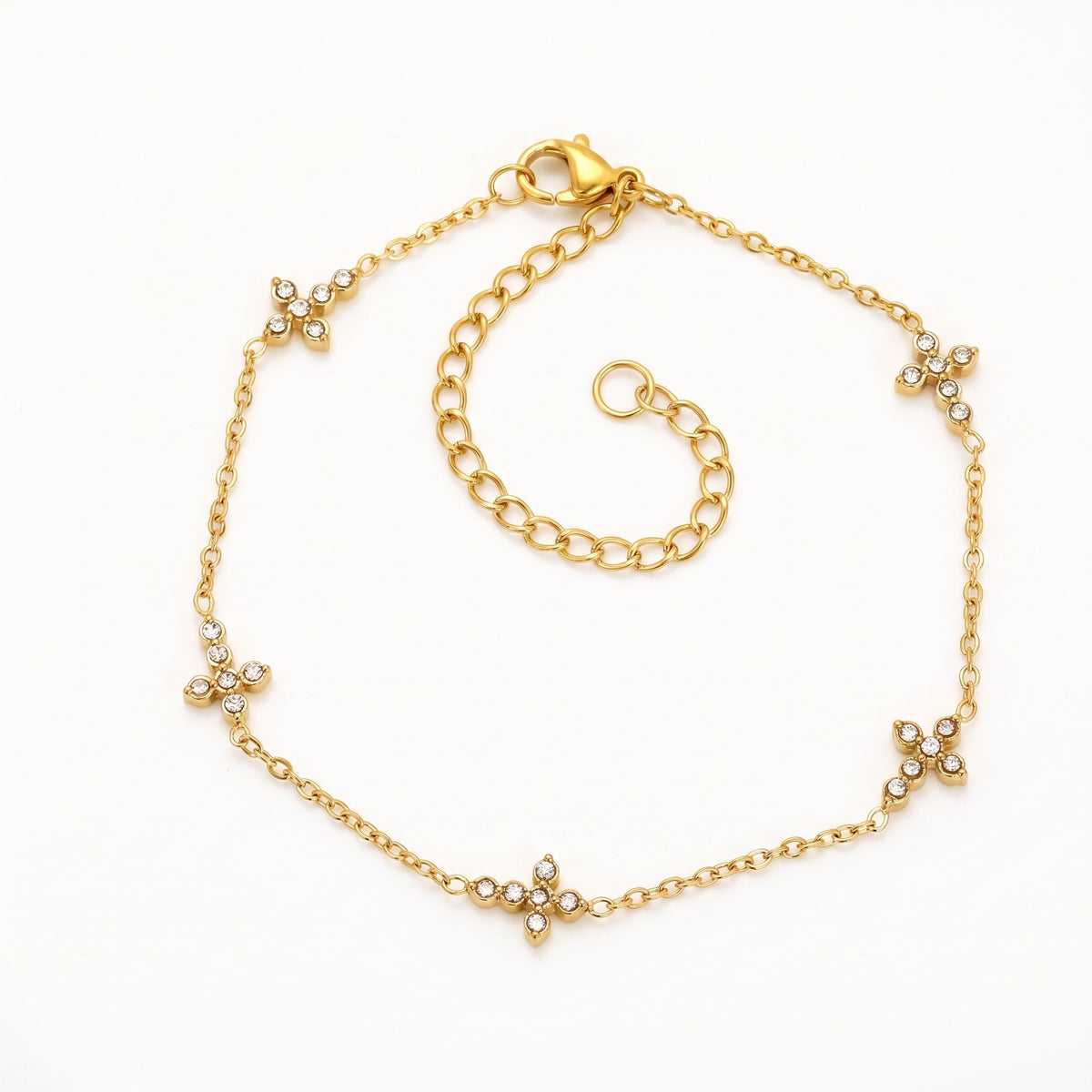 Gold-tone crystal cross bracelet, laid out flat