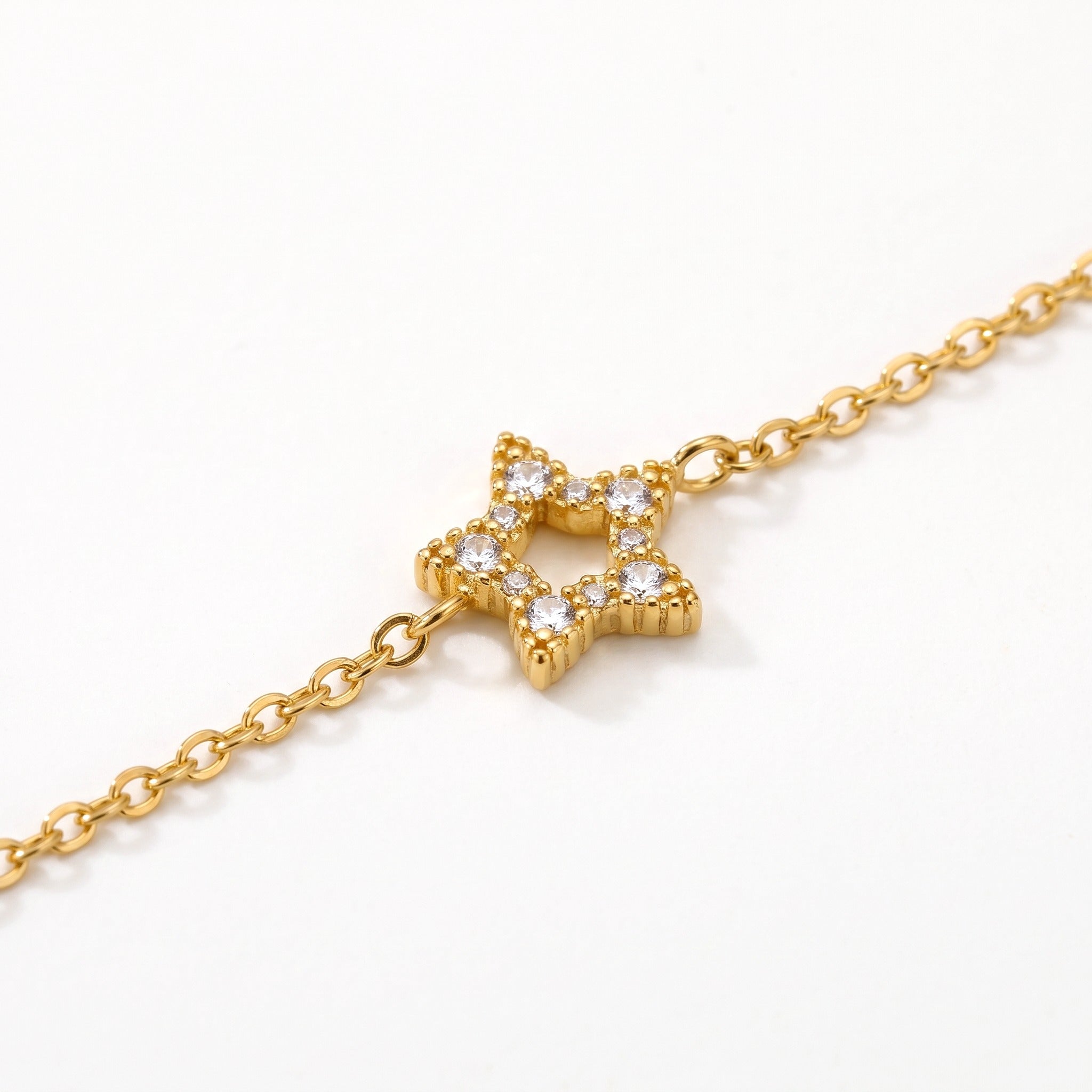 Close-up of an open star charm set with crystals on the gold-tone chain