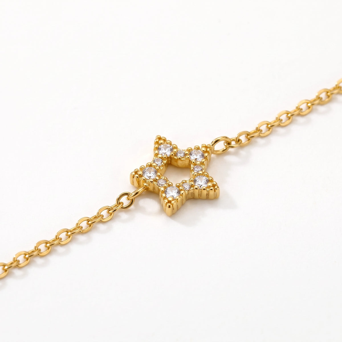 Close-up of an open star charm set with crystals on the gold-tone chain