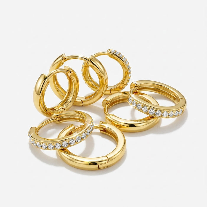 Gold-tone mini hoop earrings, plain and crystal-set, laid out together