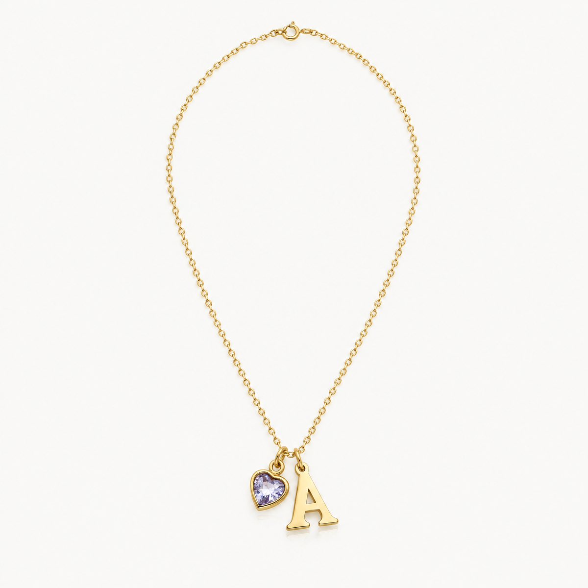 Full length of the gold-tone initial necklace with heart birthstone, laid flat
