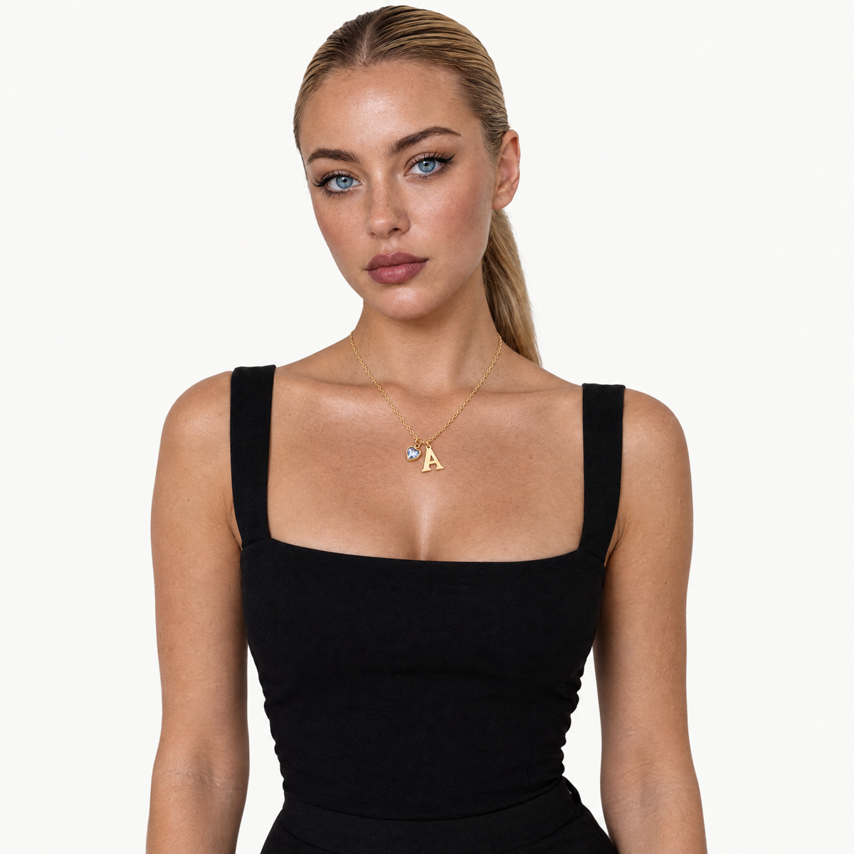 Model in a black top wearing the gold-tone initial birthstone necklace