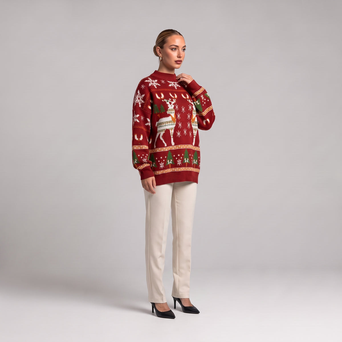 Red oversized Christmas jumper side view, worn with cream trousers