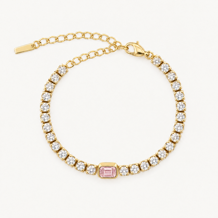 Gold-tone tennis bracelet with pink centre stone and extender chain, laid flat