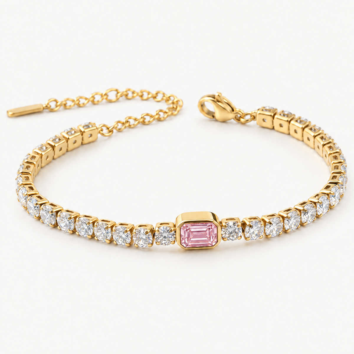 Gold-tone tennis bracelet with a pink emerald-cut centre stone, angled view