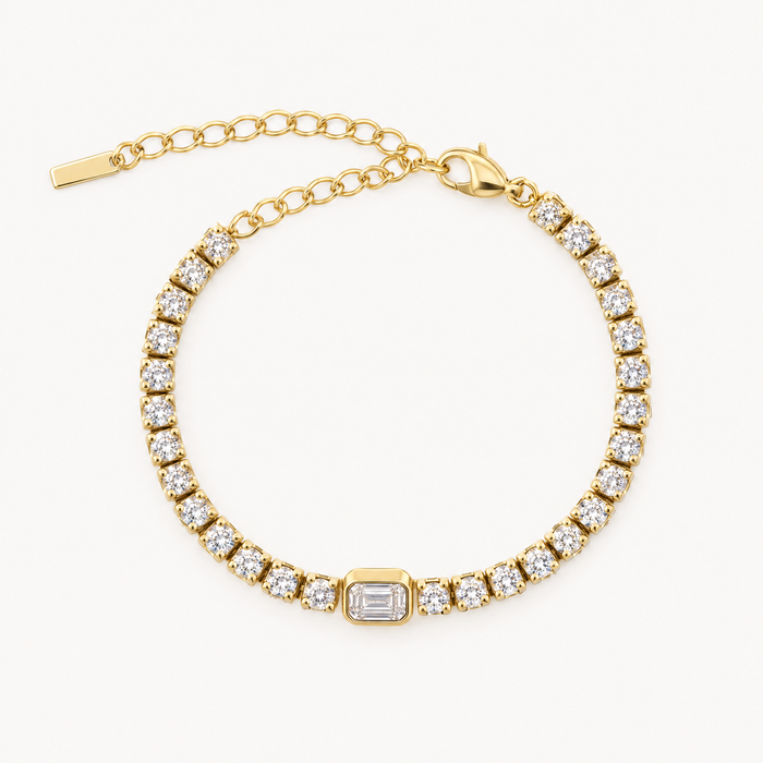 Gold-tone tennis bracelet with centre stone and extender chain, laid flat