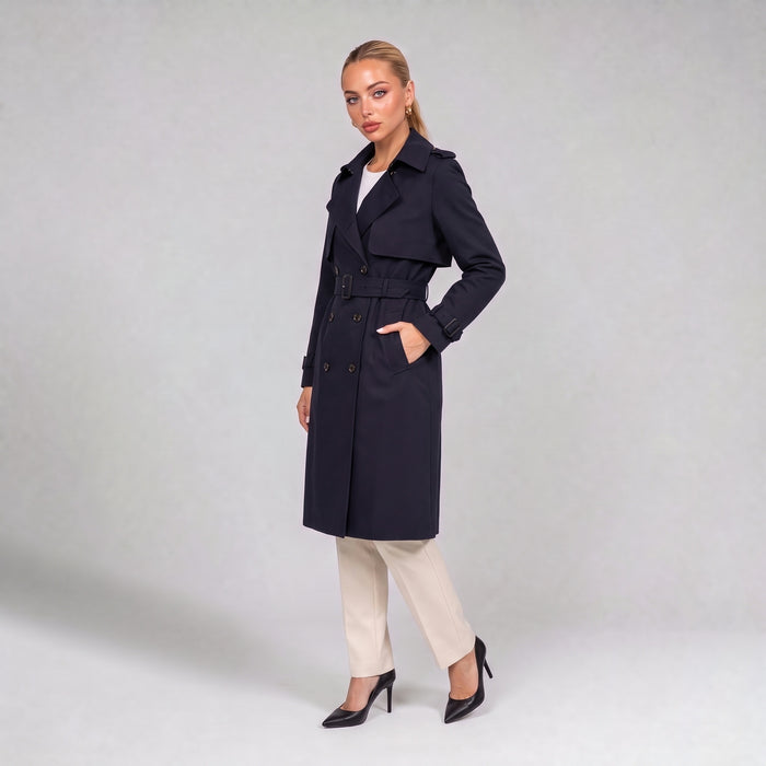 Navy double breasted trench coat with belt, three quarter view on model