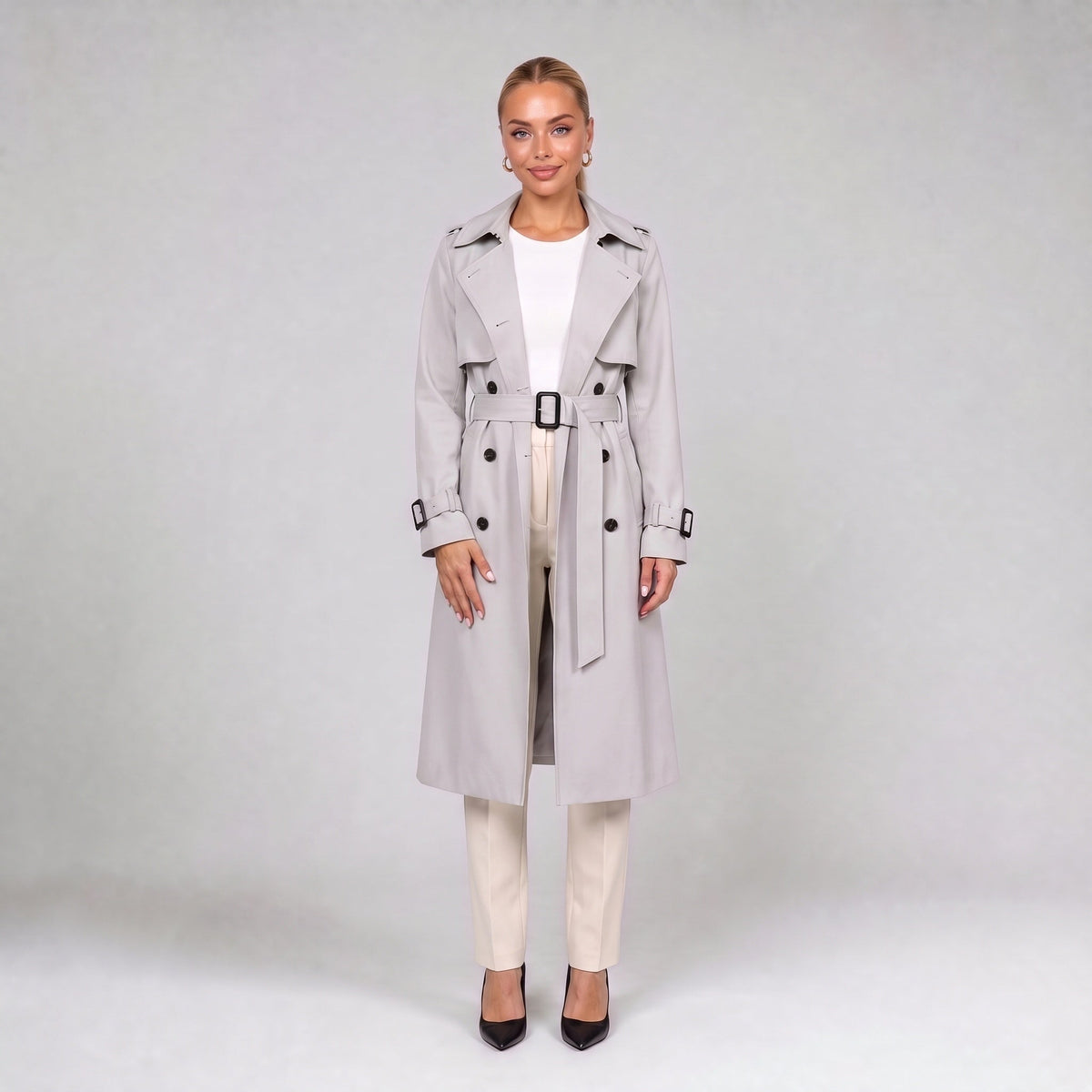 Off white double breasted trench coat with belt, full length front view on model