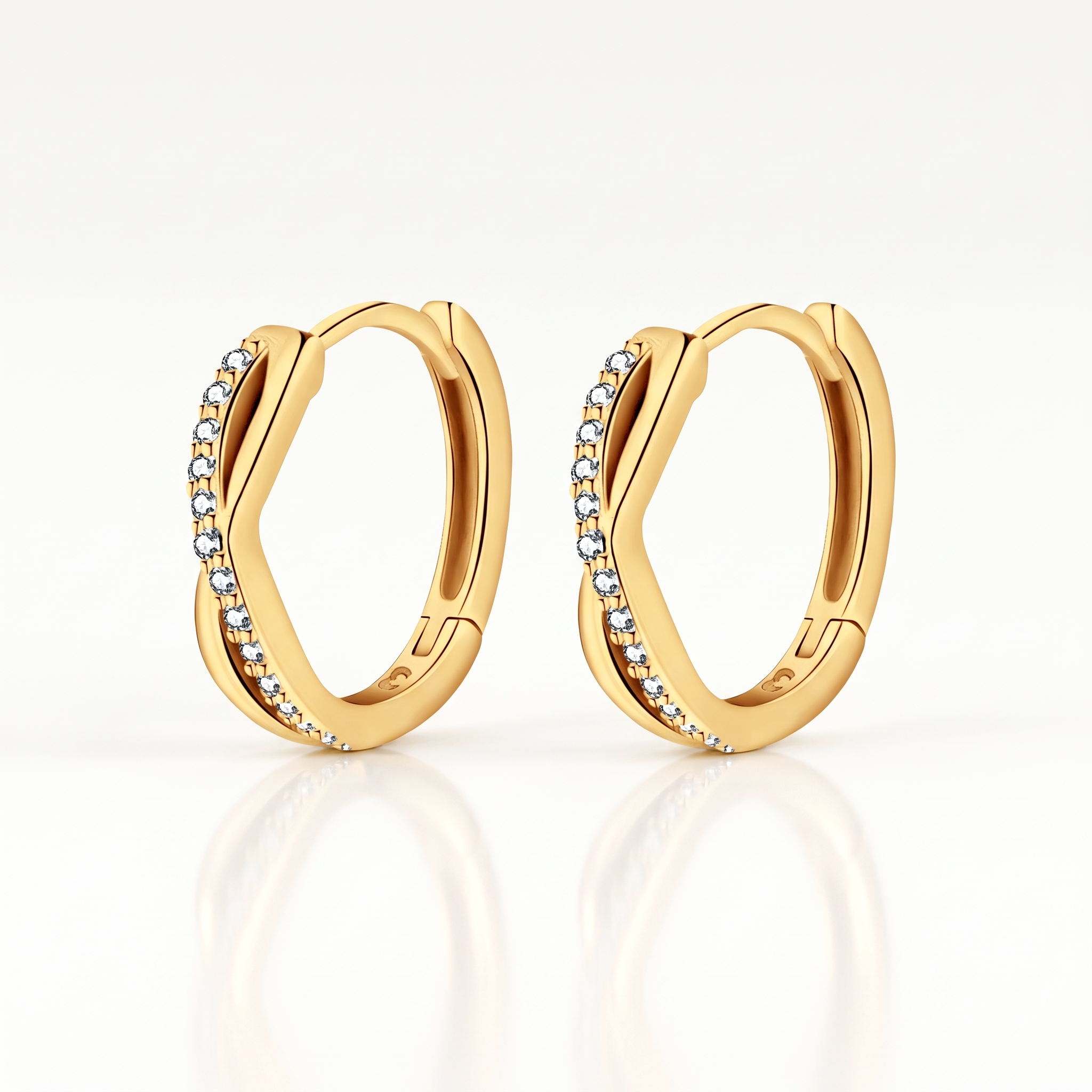 Gold-tone twisted crystal huggie hoop earrings, pair shown from the front