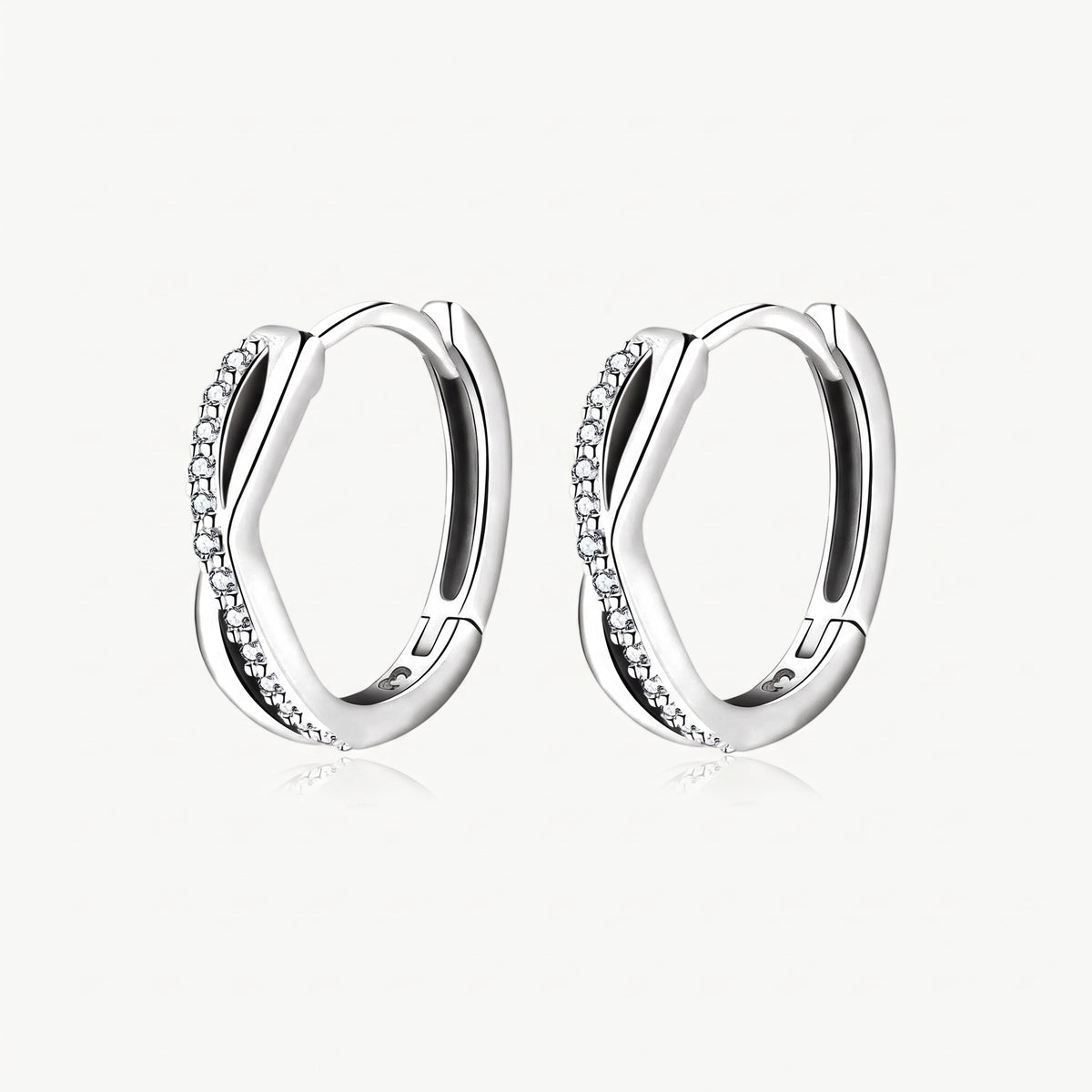 Silver-tone twisted crystal huggie hoop earrings, pair shown from the front