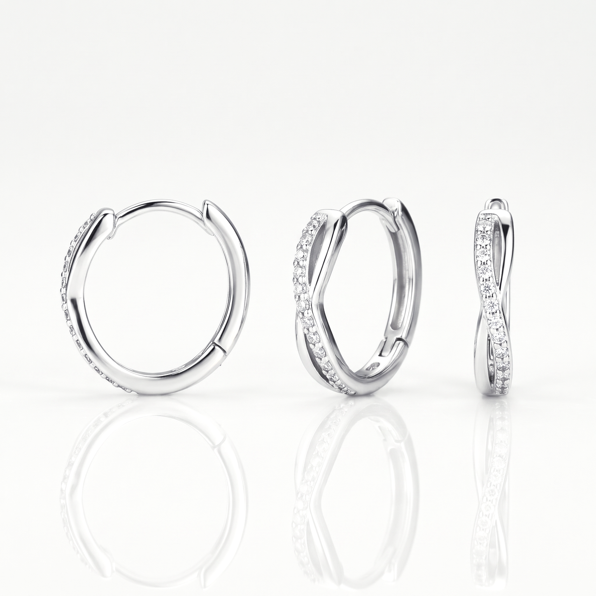 Silver-tone twisted crystal huggie hoop earring shown from the front, at an angle and from the side