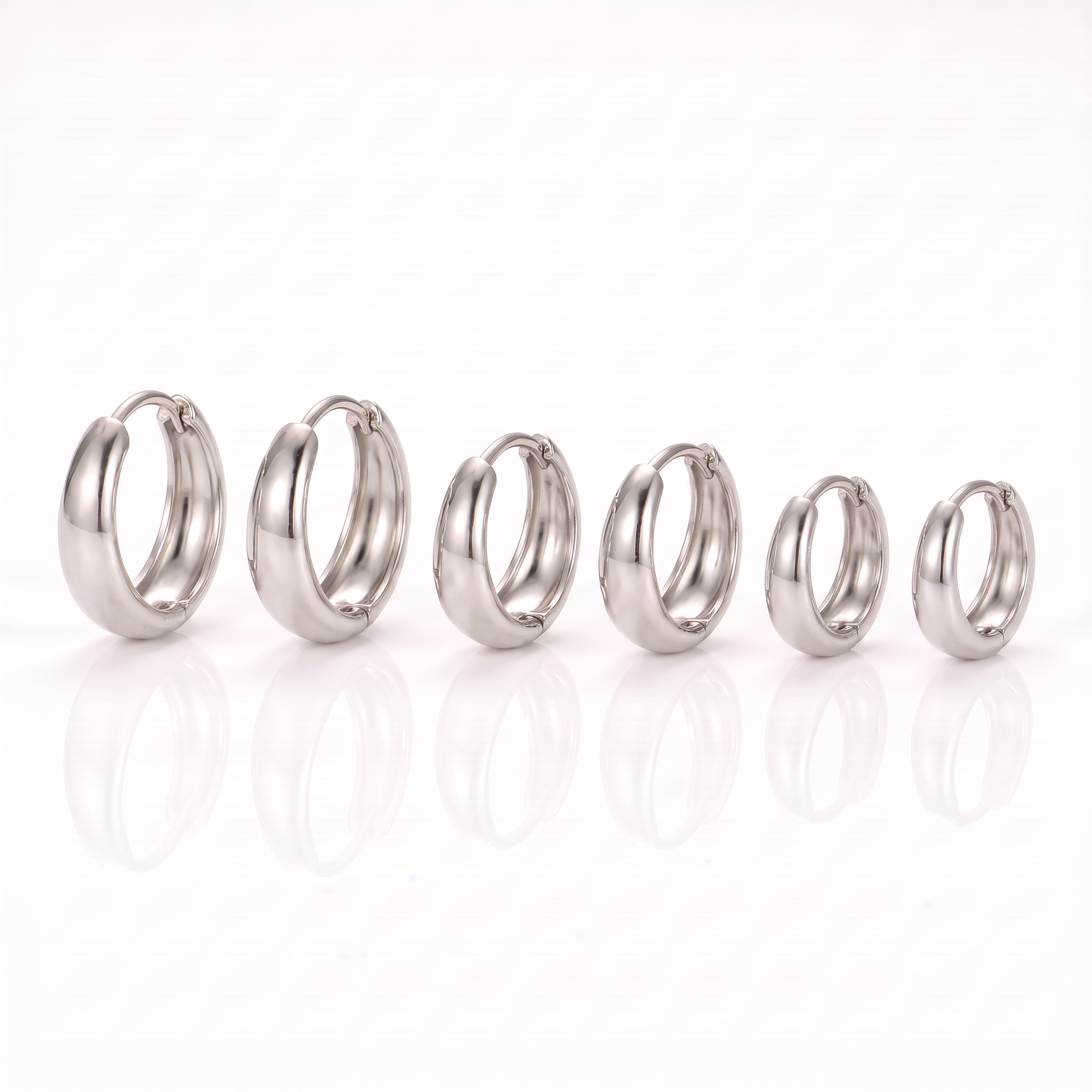 Three pairs of silver-tone chunky hoop earrings in three sizes