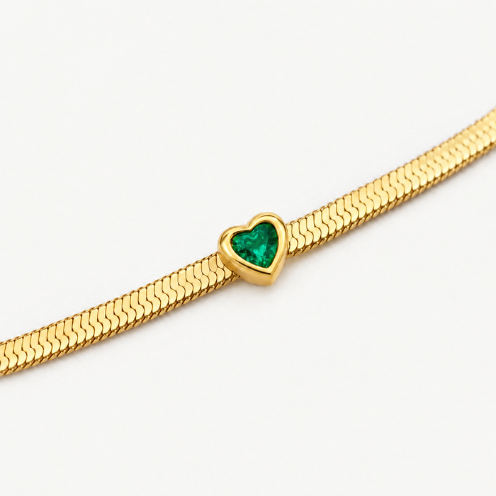 Close up of the green heart birthstone on the herringbone chain