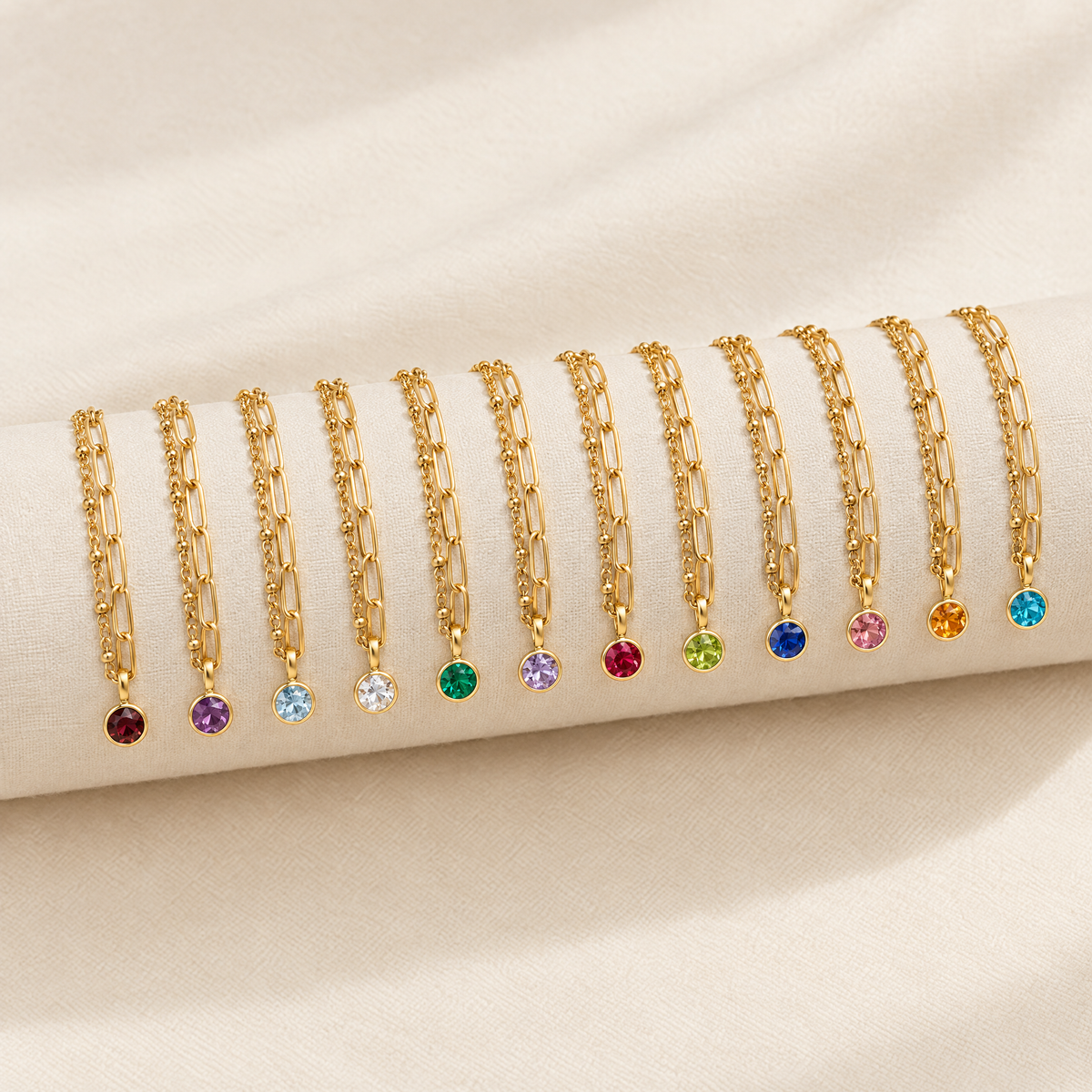 Twelve layered paperclip birthstone bracelets, one for each month