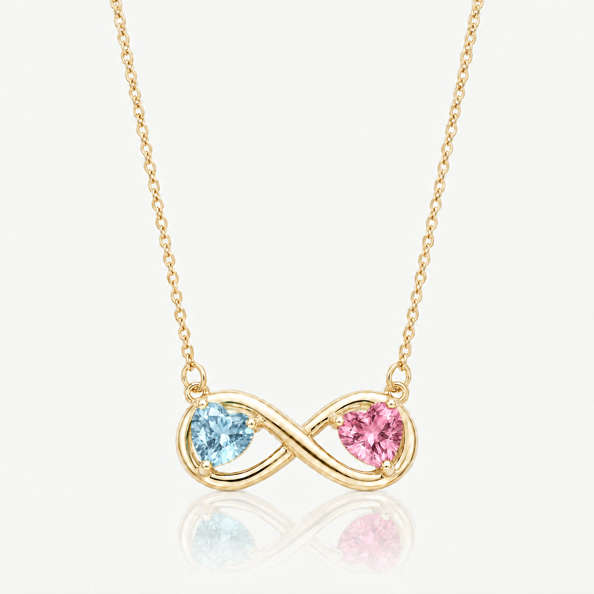 Gold-tone infinity necklace with light blue and pink birthstone hearts