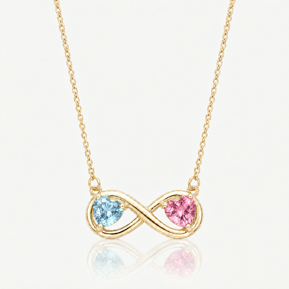 Gold-tone infinity necklace with emerald green and ruby red birthstone hearts