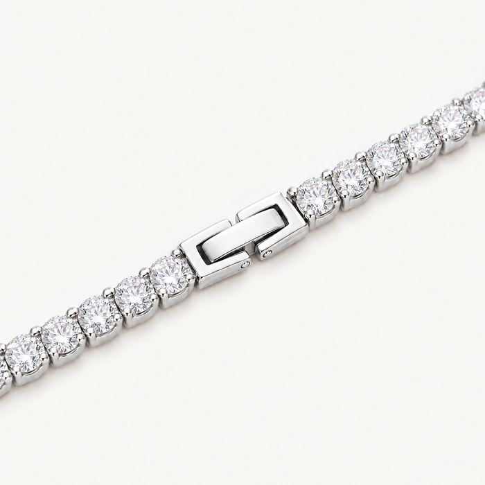 Close up of the claw-set stones and box clasp of the silver-tone tennis bracelet