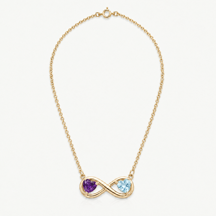 Full length of the gold-tone infinity necklace with amethyst and aquamarine hearts, laid flat