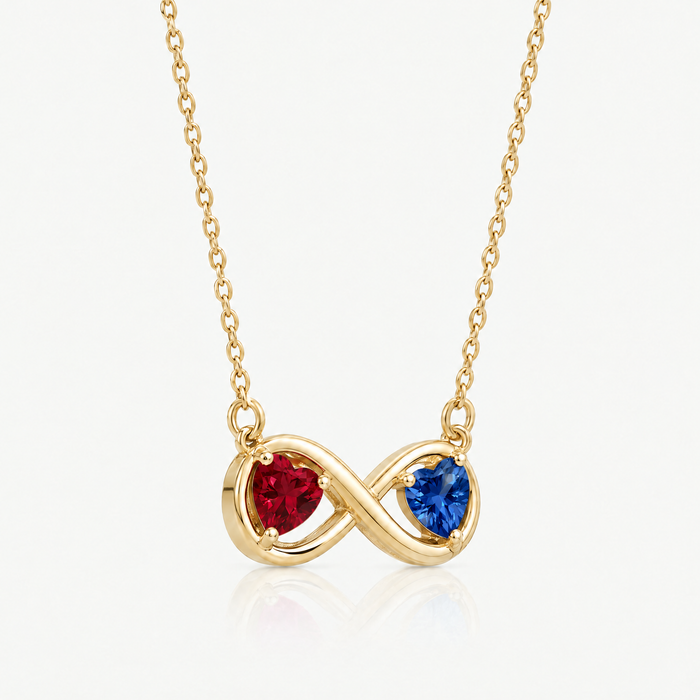 Gold-tone infinity pendant with ruby red and sapphire blue hearts, angled view