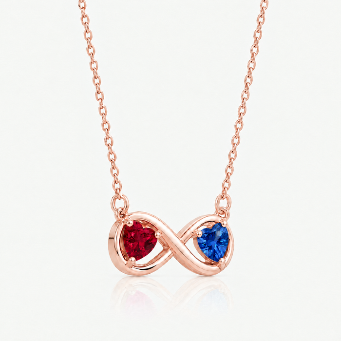 Rose gold-tone infinity pendant with ruby red and sapphire blue hearts, angled view