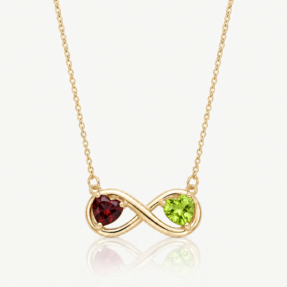 Gold-tone infinity necklace with garnet red and peridot green birthstone hearts